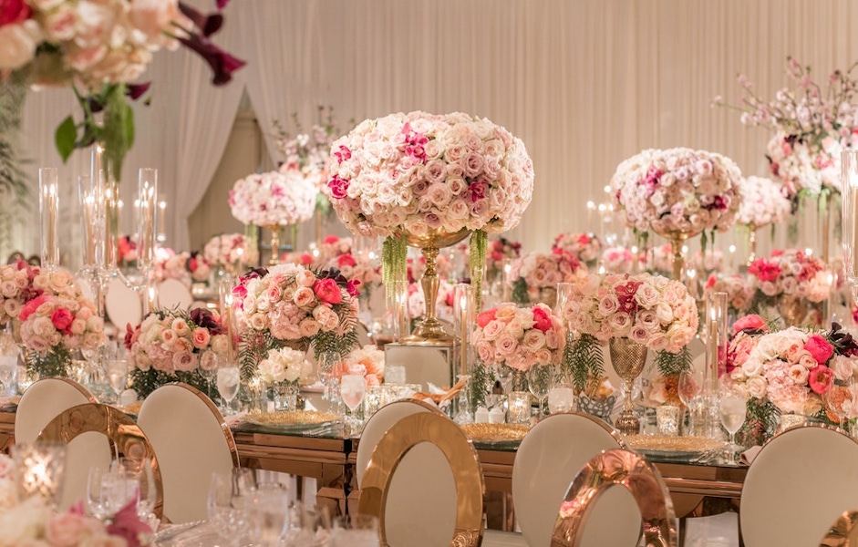 big white and pink floral centerpieces with white chairs and gold accents