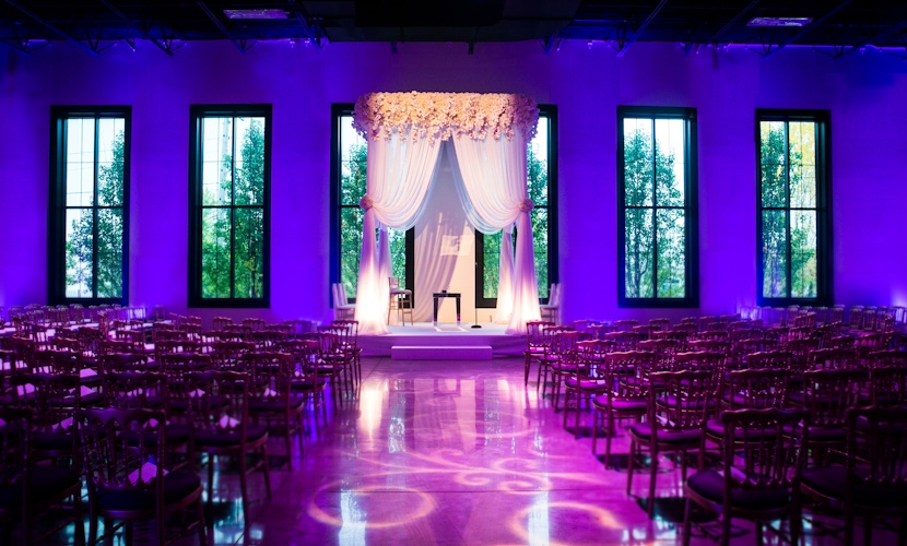 Floral wedding arbor and purple backdrop lighting
