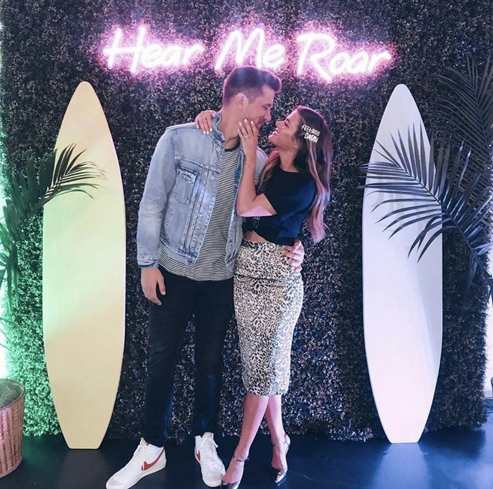 Jojo Fletcher and Jordan Rodgers at Shop Fletch pop up shop in Chicago posing in front of branded living wall