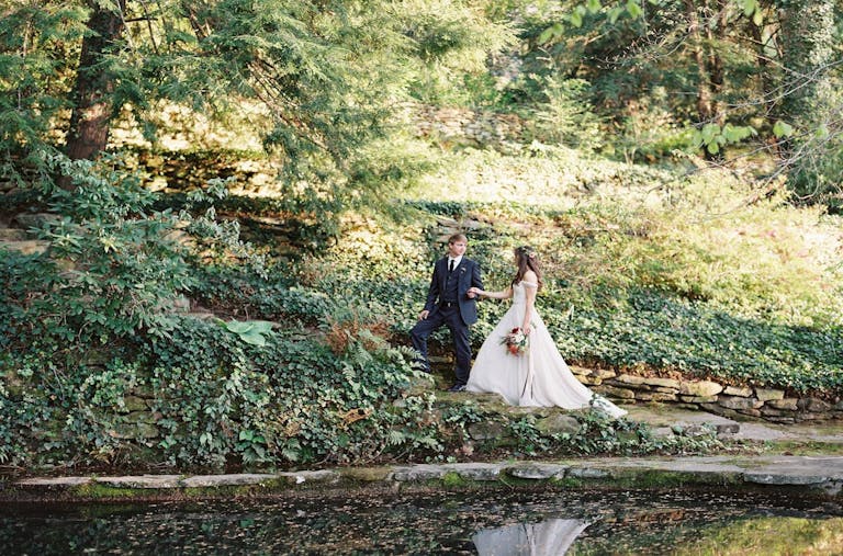 Bride and groom walking through lush greenery