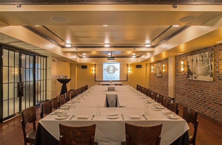 Wide table in front of projector with exposed brick walls at Theodore Ascher Room, a corporate event space in Chicago | PartySlate