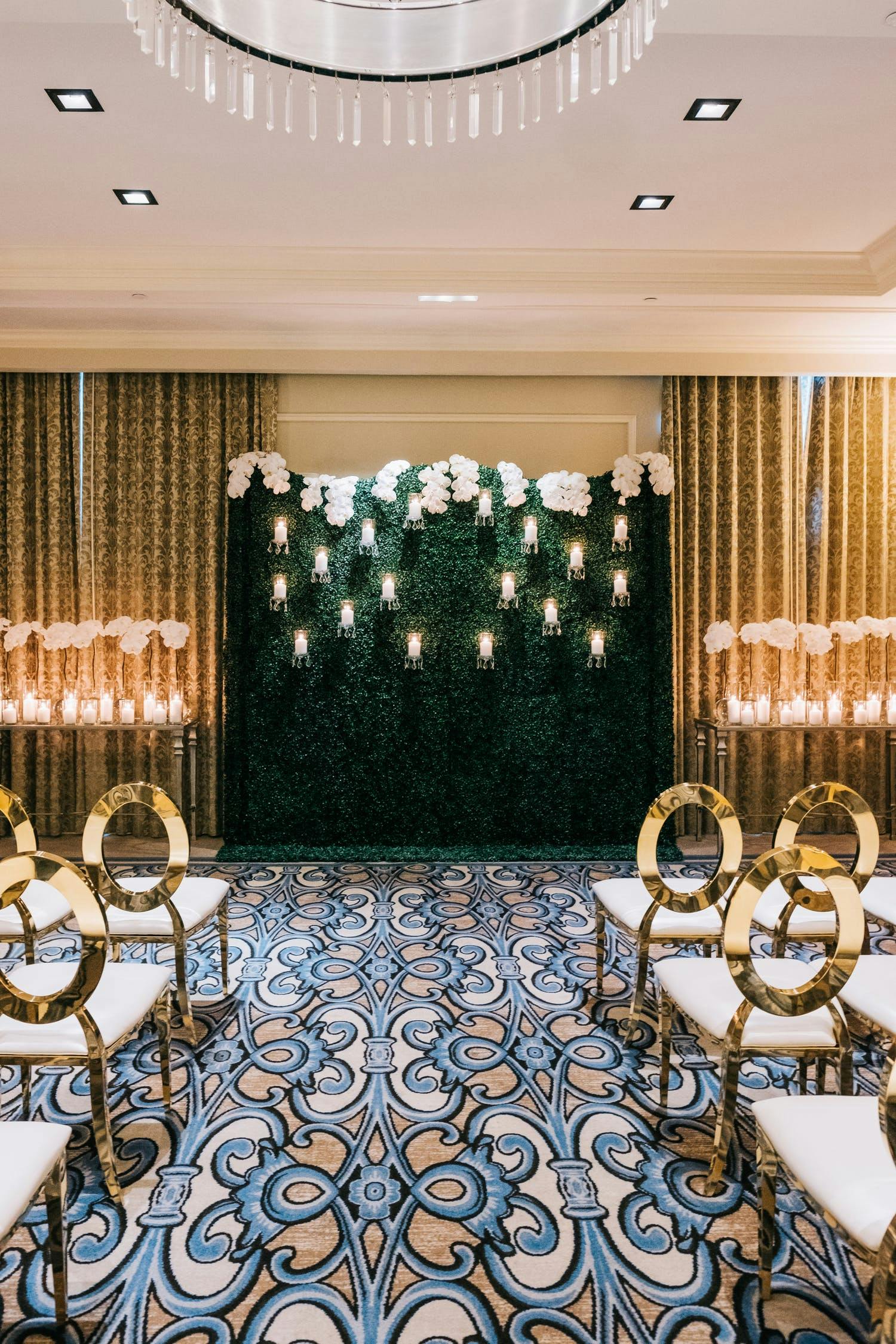 ballroom set up for wedding ceremony with boxwood backdrop