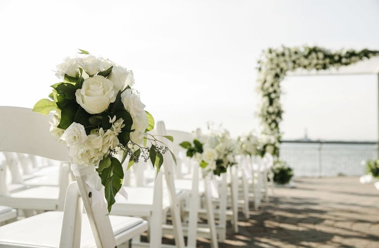 Seaside ceremony with white roses | PartySlate