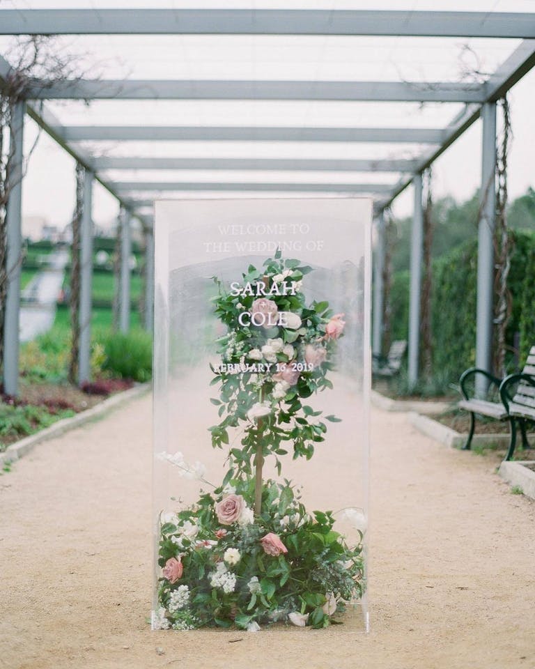 greenery and bloom sculpture encased in glass box | PartySlate