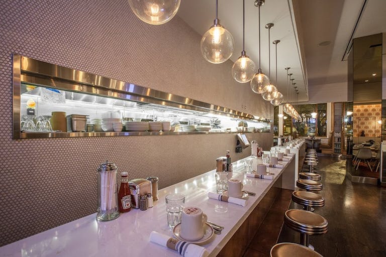 Glossy white table and bar stools at Little Goat Diner, a classic diner with a modern twist | PartySlate