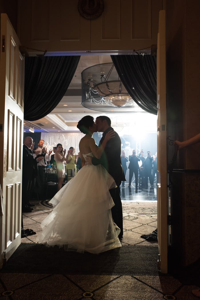 Bride and groom kiss in doorway | PartySlate