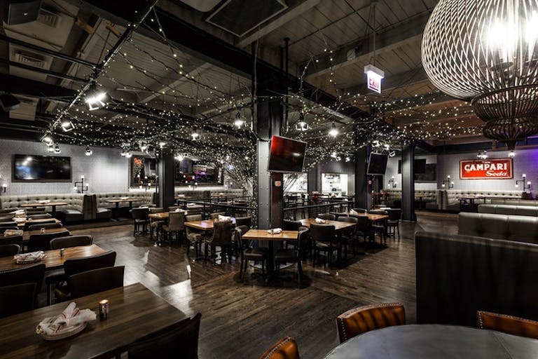 Casual restaurant with dangling lights, dark hardwood floors and barn-like ceiling | PartySlate