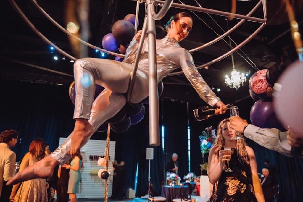 Female aerialist suspended from geometric shape