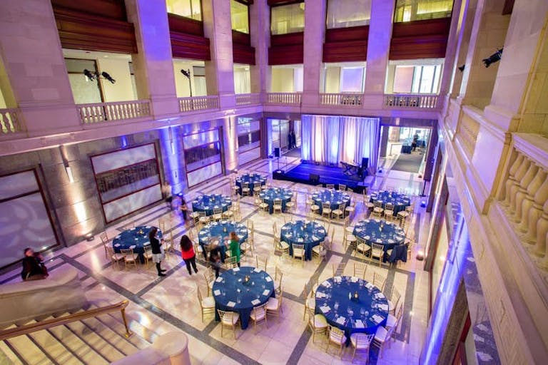 Round blue tables in atrium-style ballroom at Builders BLDG in Chicago | PartySlate