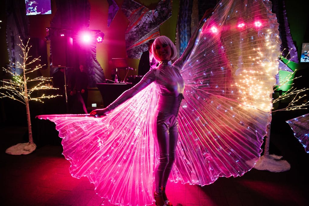 Woman dressed as butterfly with pink up-lit wings | PartySlate