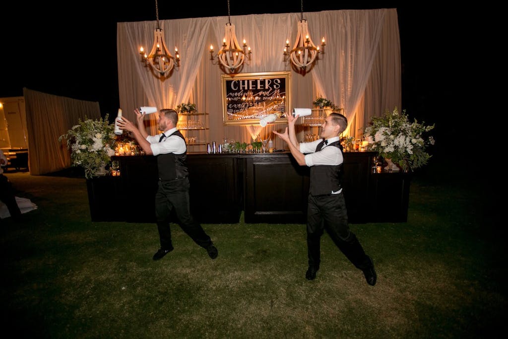 Flair bartenders performing at outdoor wedding