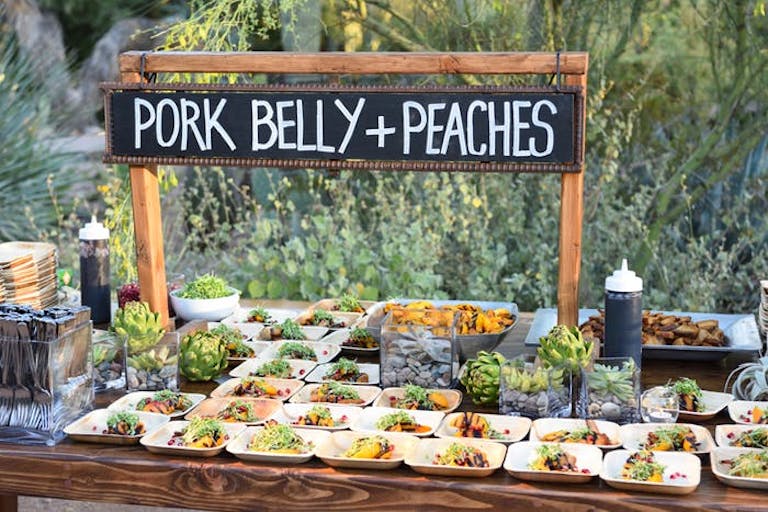 Rustic wooden food table with chalkboard sign | PartySlate