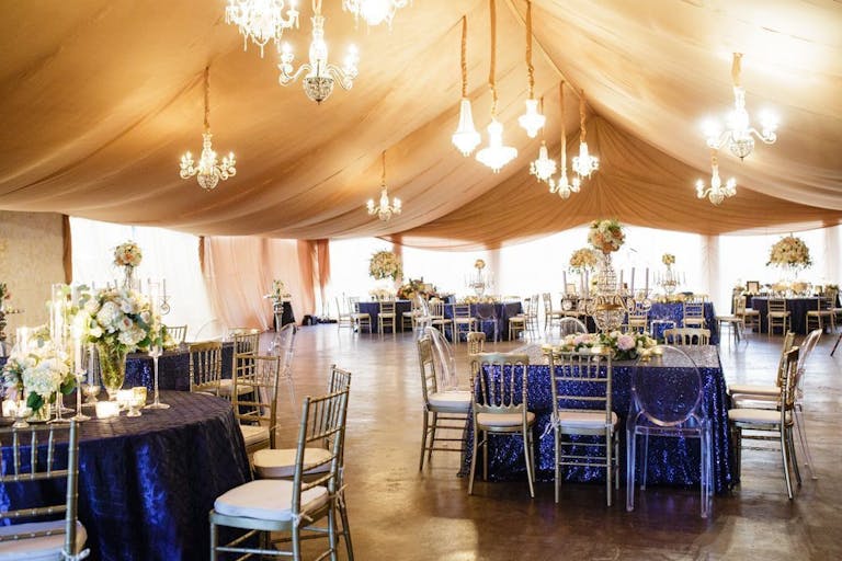 gold-tented pavilion with glittering chandeliers and blue-draped tables