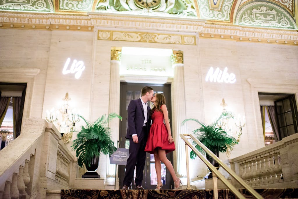 Couple kissing on top of stairway at Palmer House Hilton in Chicago for a wedding rehearsal dinner party | PartySlate