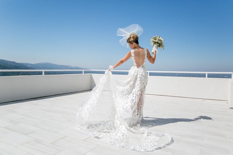 bride posing on white deck surrounded by blue skies