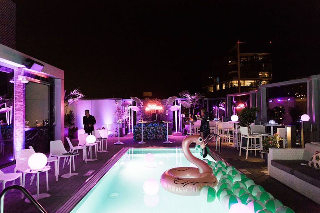 Pool area with flamingo floaty and violet uplighting