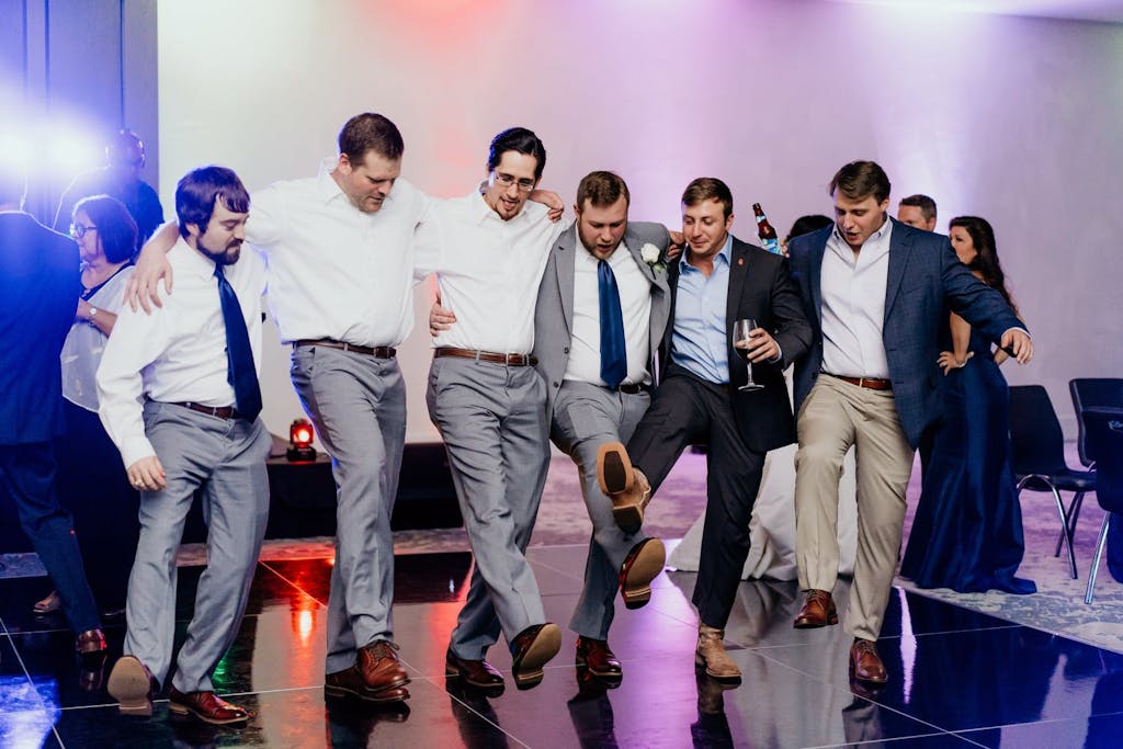 Group of male friends dancing in a line