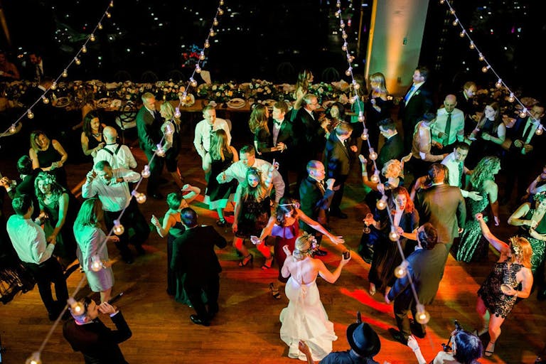 party goers dancing under stringed lights