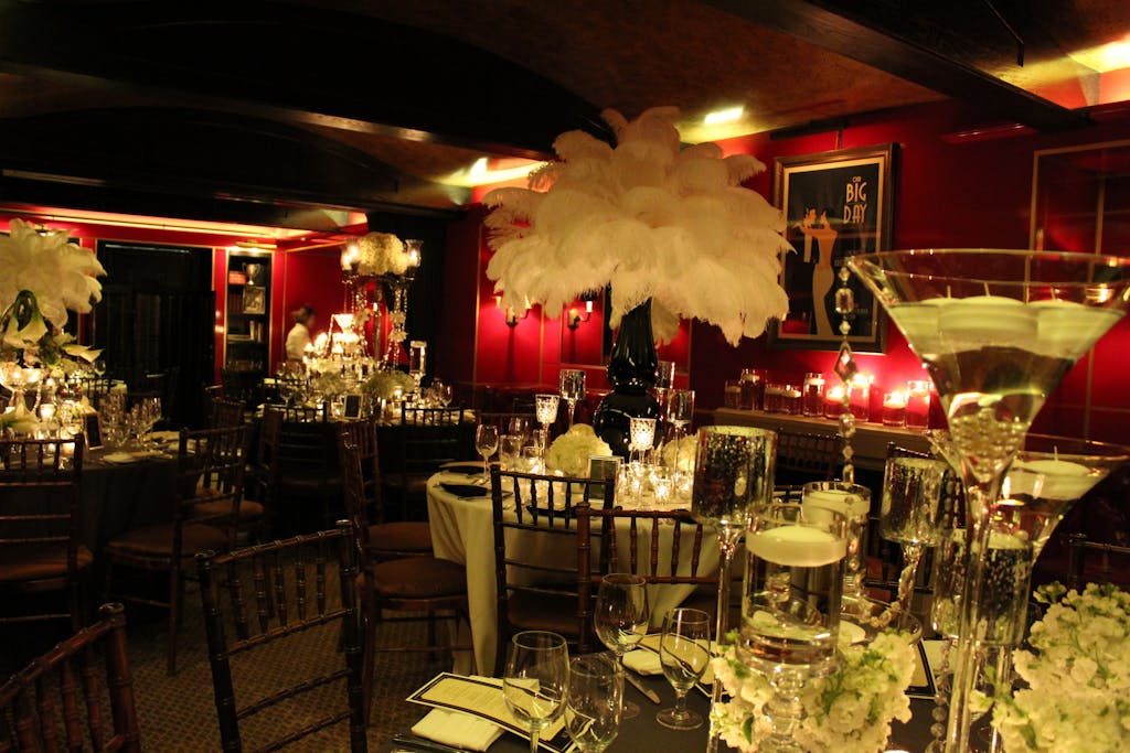 Tortoise Supper Club decorated with white feather centerpieces for Great Gatsby-themed wedding rehearsal dinner party | PartySlate