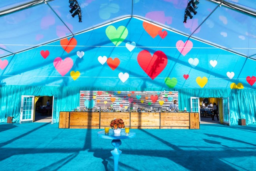blue lit tent with hearts floating above the scene