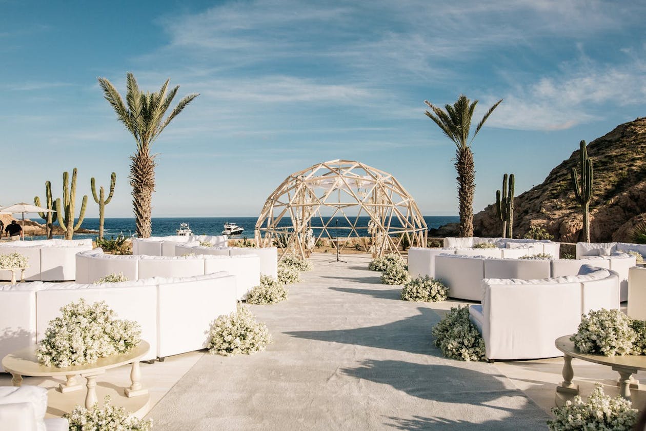 geometric wedding ceremonial arch and lounge seating against ocean backdrop