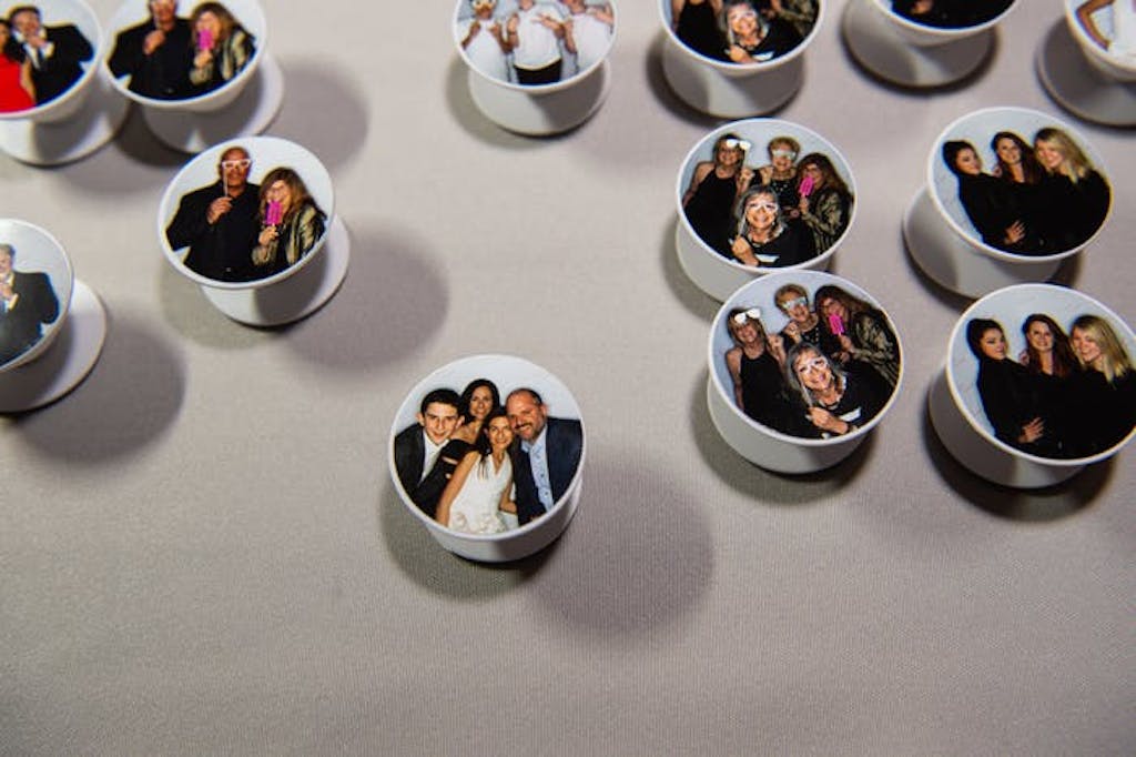 pop sockets with photo booth photos on them decorate a table. 
