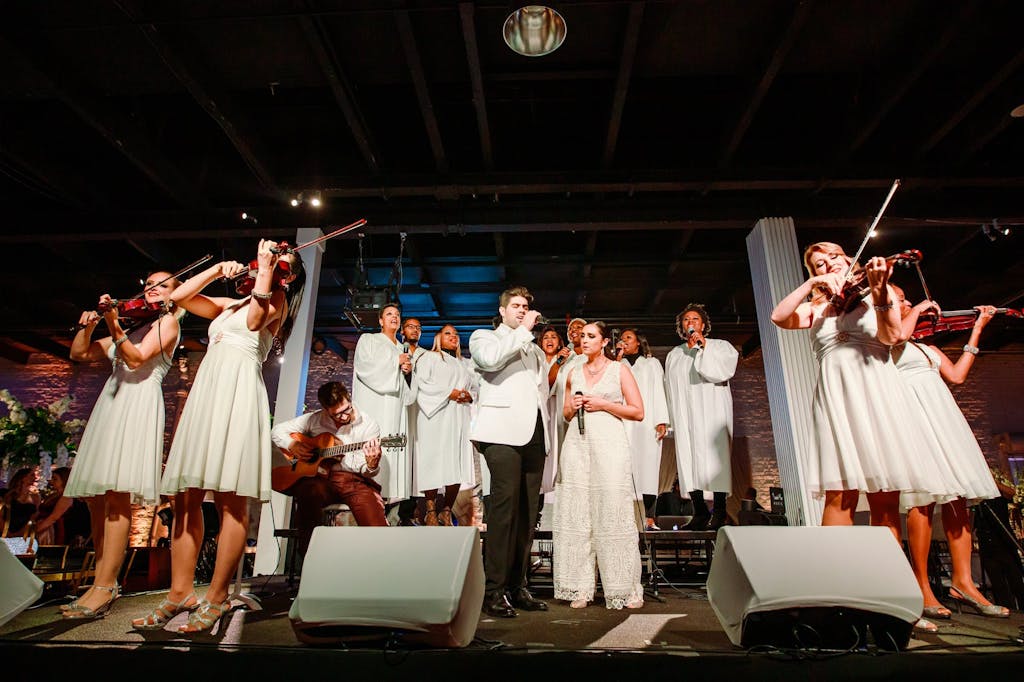 band and orchestra performing dressed in all white
