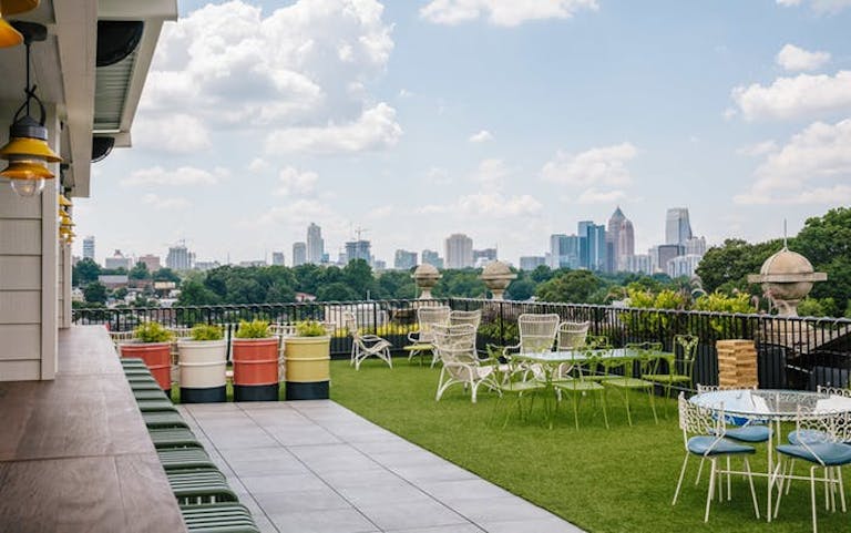 Outdoor lawn with tables and chairs and a beautiful view of the Atlanta skyline.