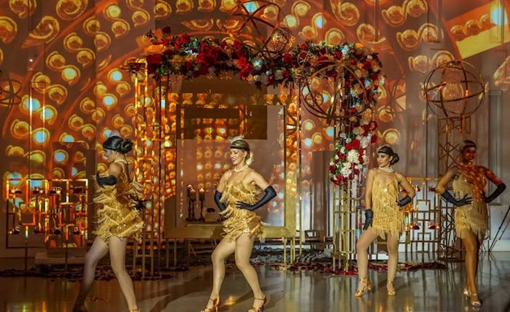 golden dancers in fringed dresses entertain at gatsby themed celebration