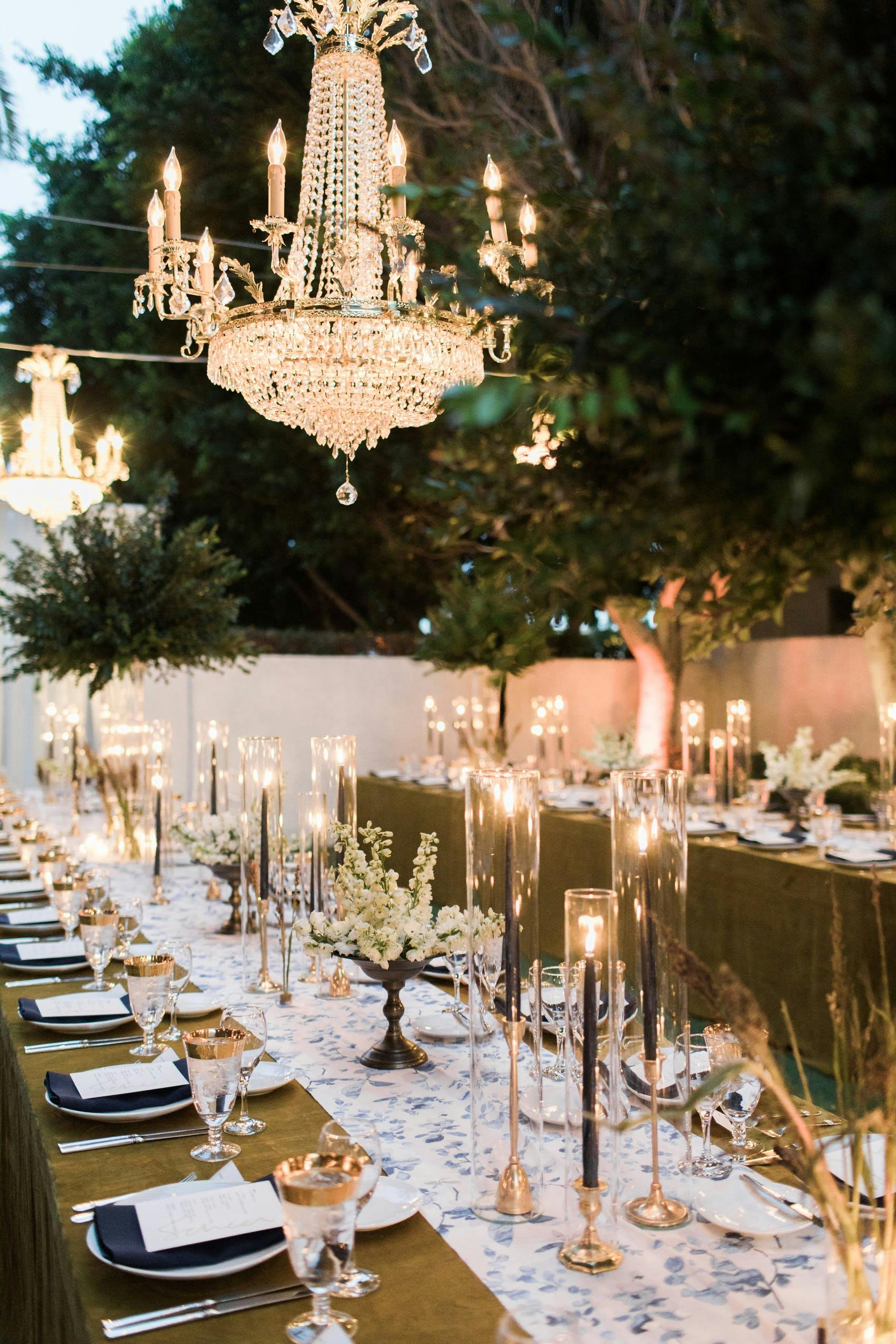 Large black candles with large white chandelier hanging down.