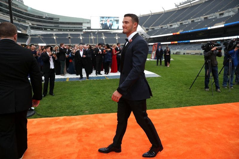Man in tux walks on orange carpet in Soldier Field.