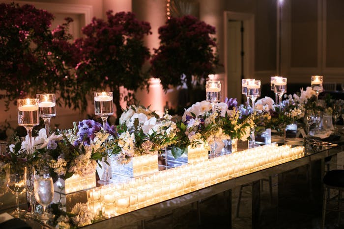 long table with many small orchid wedding centerpieces