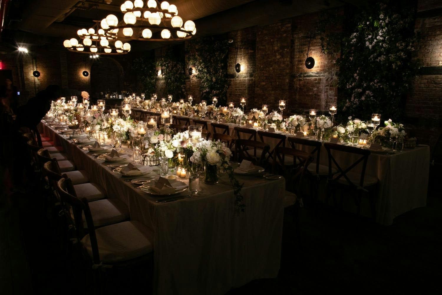Long table in dark room with candles along the table.