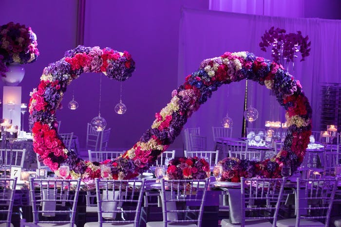 A centerpiece that extends the length of the table. Flowers arranged into an 'S' shape on its back to sit length wise on the table