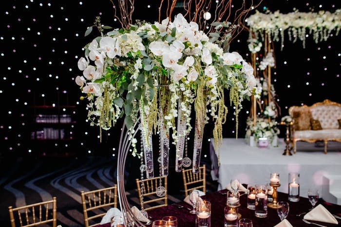 black background with tall overhanging white orchid wedding centerpieces