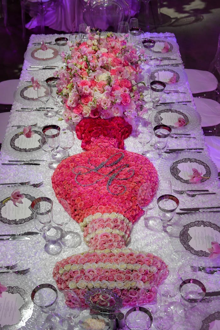 Centerpiece made of flowers in the shape of a vase and pink and white florals coming out the top
