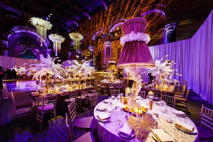 a purple lit room with vintage chandeliers and decorative centerpieces
