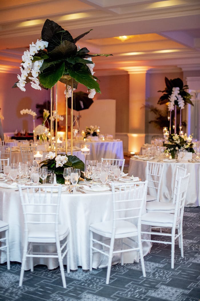tall centerpieces with large leaves and hanging white orchids