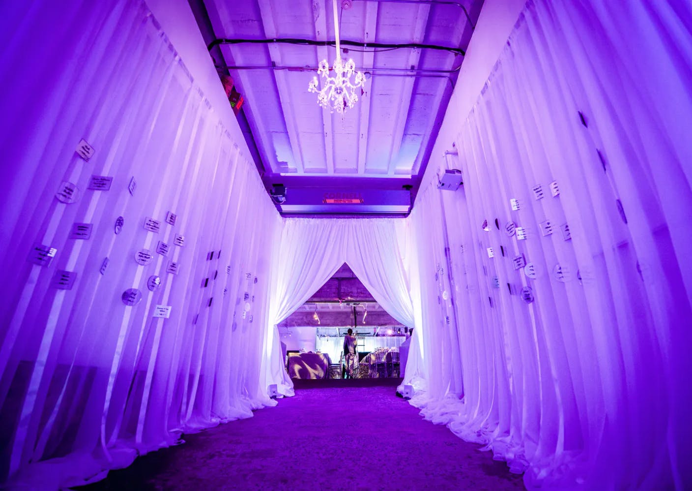 Birthday Party Entrance with Drapery and Purple Uplighting | PartySlate