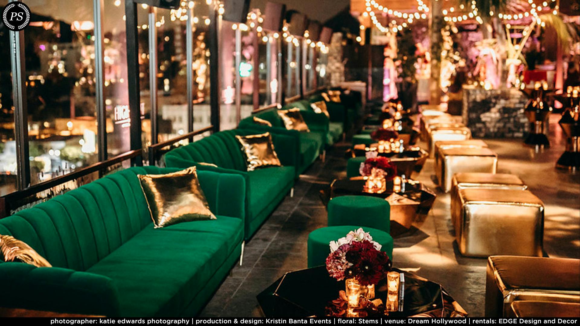 A row of green velvet couches along a mirror reflecting gold accents and tables