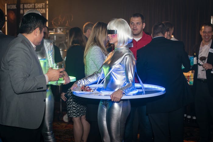 Futuristic Party With Woman in a Platinum Blonde Wig With a Silver Space Uniform and Tray Surrounding Her | PartySlate