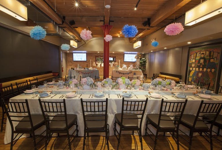 Sunda New Asian baby shower venue in Chicago with long tables with white linens and black chairs. Colorful balloons are above