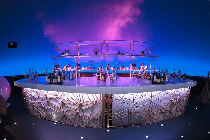 Space-Themed Party With Laser-Cut Bar Décor and Pink and Blue Uplighting | PartySlate