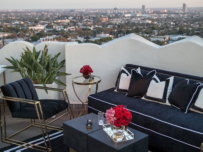 Party Lounge Area on City Rooftop With Black and White Seating and Pink Floral Centerpieces | PartySlate