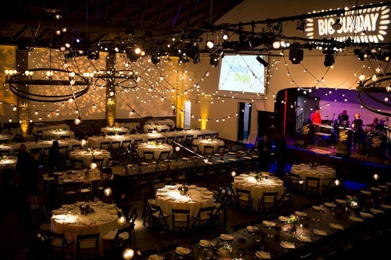 A dimly lit room with fairy lights and a monitor. Centerpieces act as spotlights