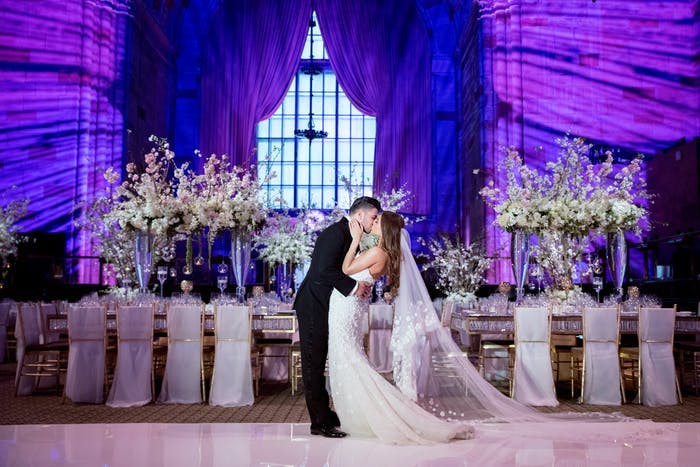 A couple kissing on the dance floor with purple and blue lighting