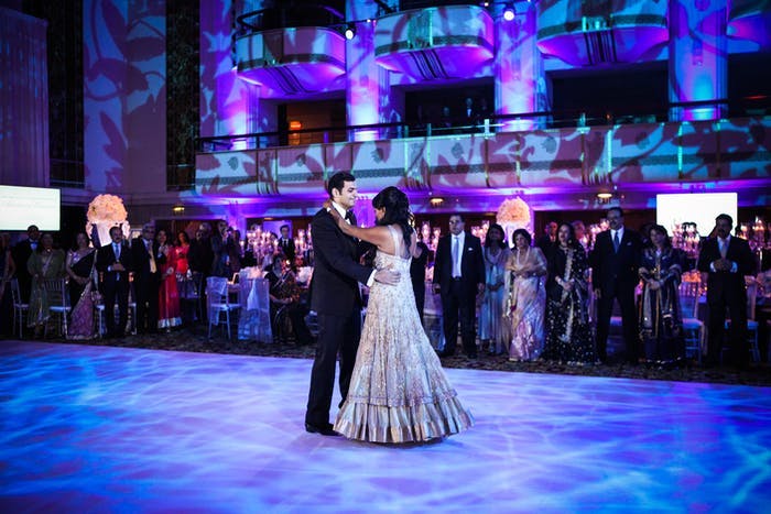 A blue and purple lit dancefloor with the couple
