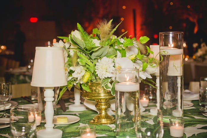 white lamps as centerpieces with greenery in the middle.