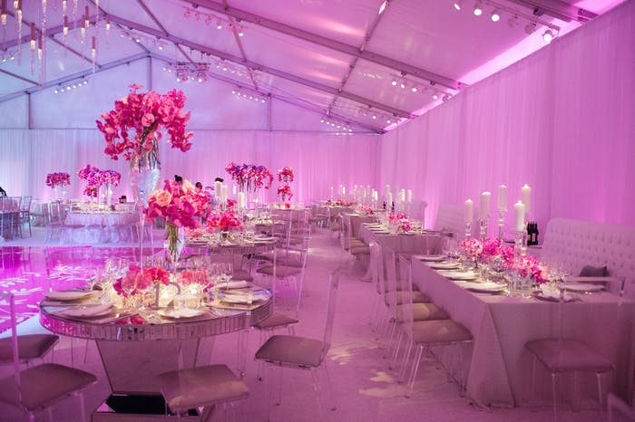 Room lit up pink with tall pink floral centerpieces