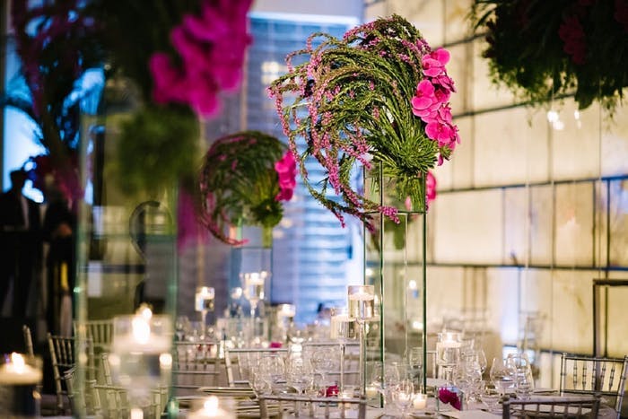 pink and green tall floral arrangements sit on each table